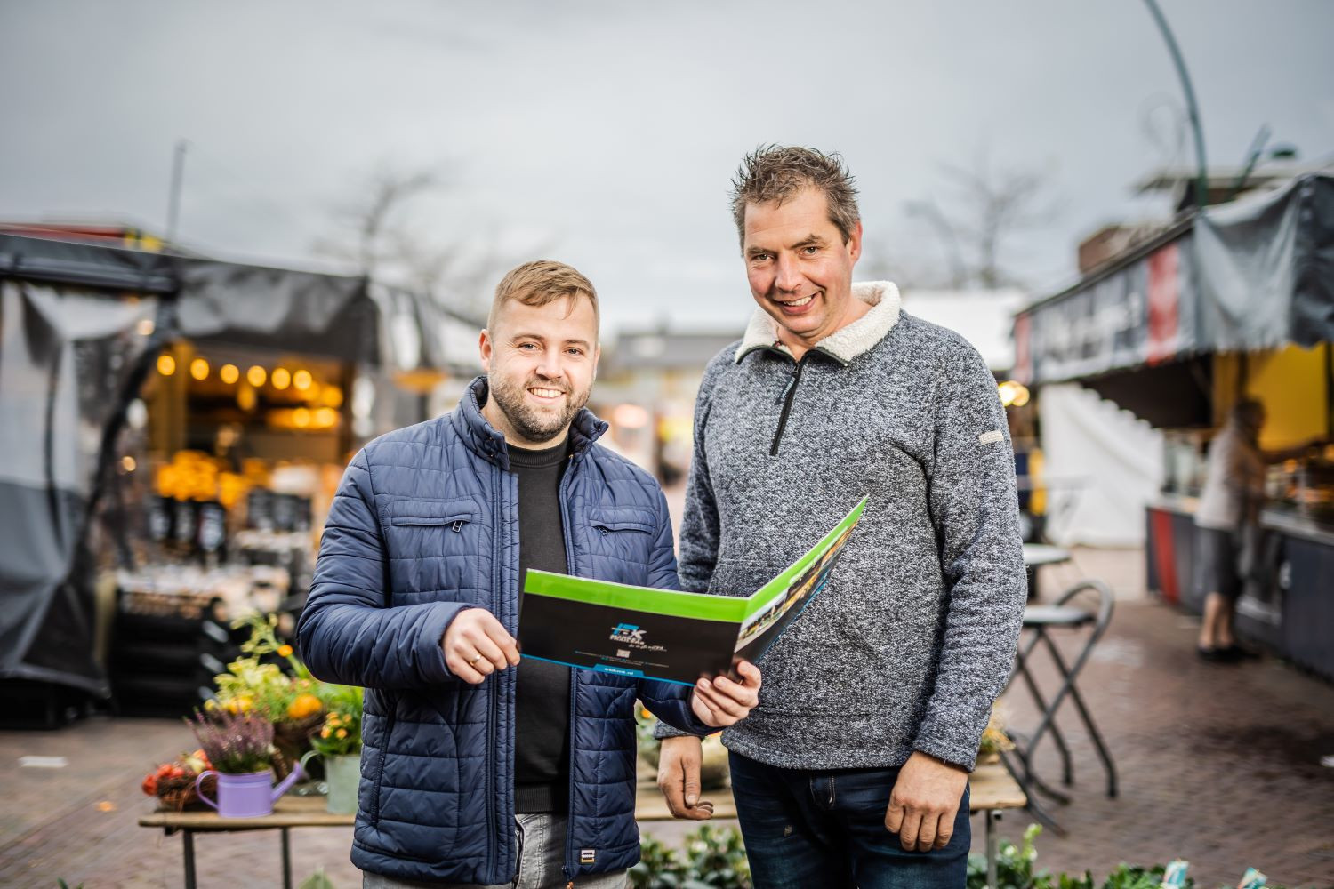 Twee mannen op de markt lachen naar de camera