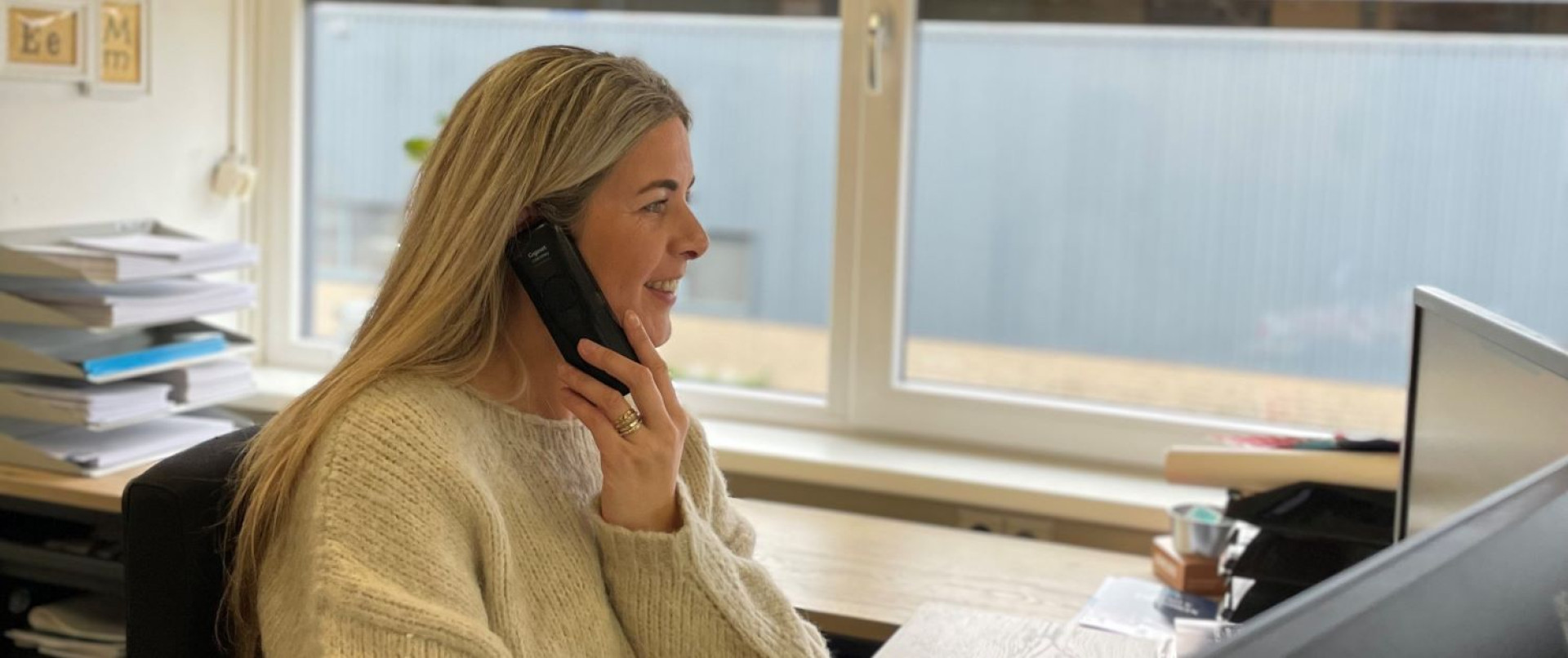 Vrouw heeft telefoon aan oor en lacht