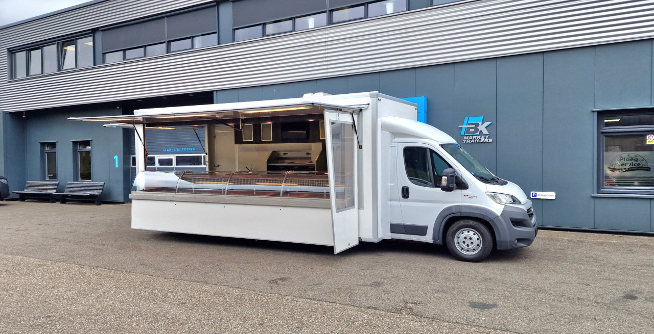 Zijaanzicht van een verkoopwagen met geopende luifel