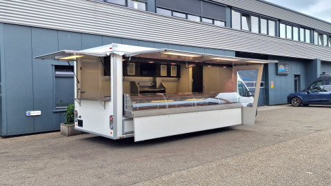 Zijaanzicht van een verkoopwagen met geopende luifel